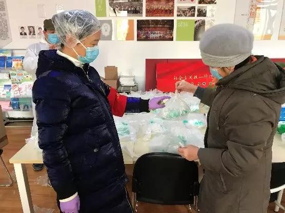 為樓棟分發(fā)口罩，并為包裝袋消毒